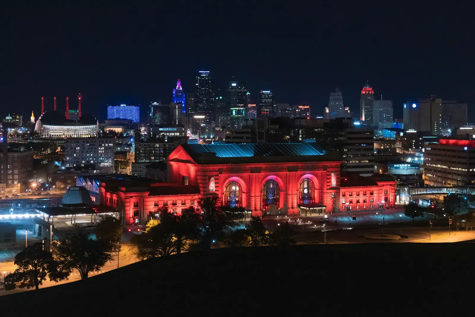 Kansas City skyline at night behind Union Station lit in red