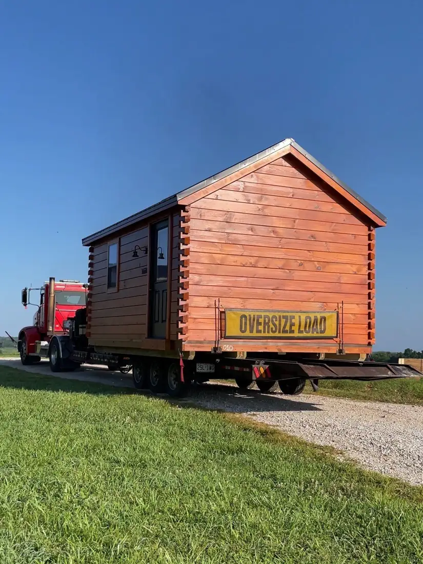The Cub loaded on a trailer behind a red truck, ready for delivery