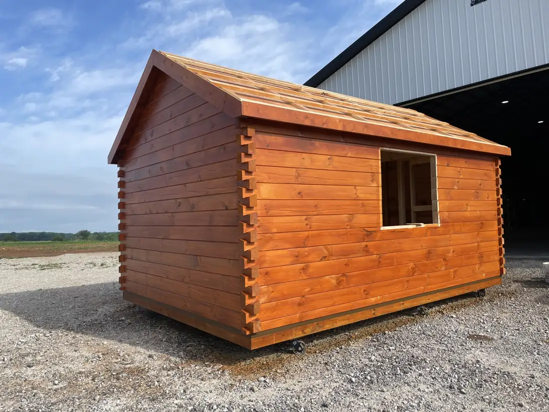 The Cub’s log walls with a window opening, outside the shop