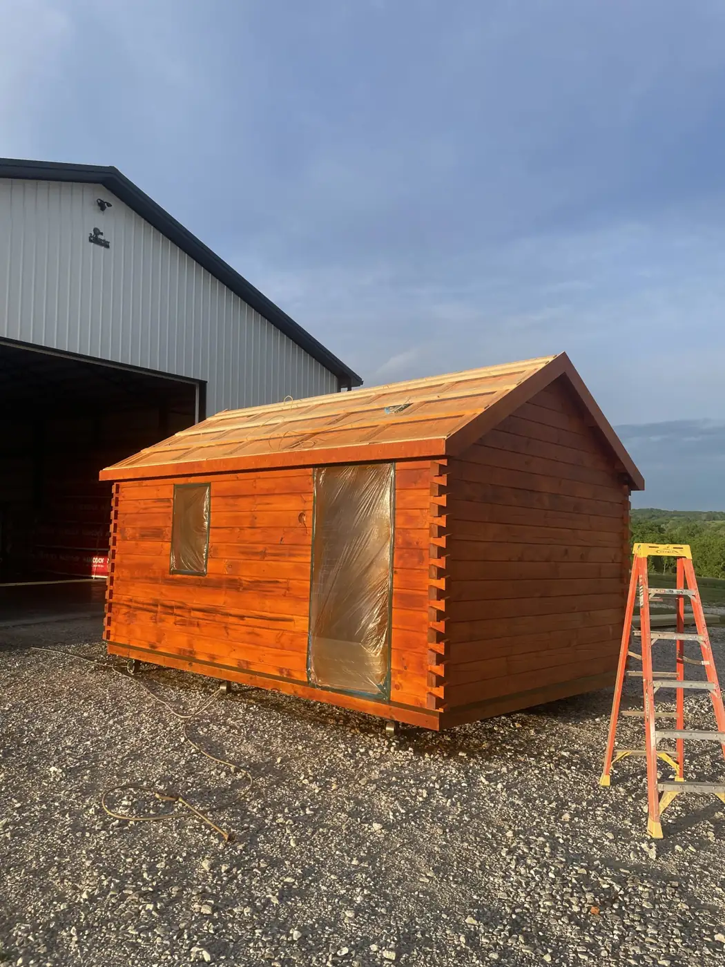 The Cub outside our shop with the log walls up, before the roof is finished