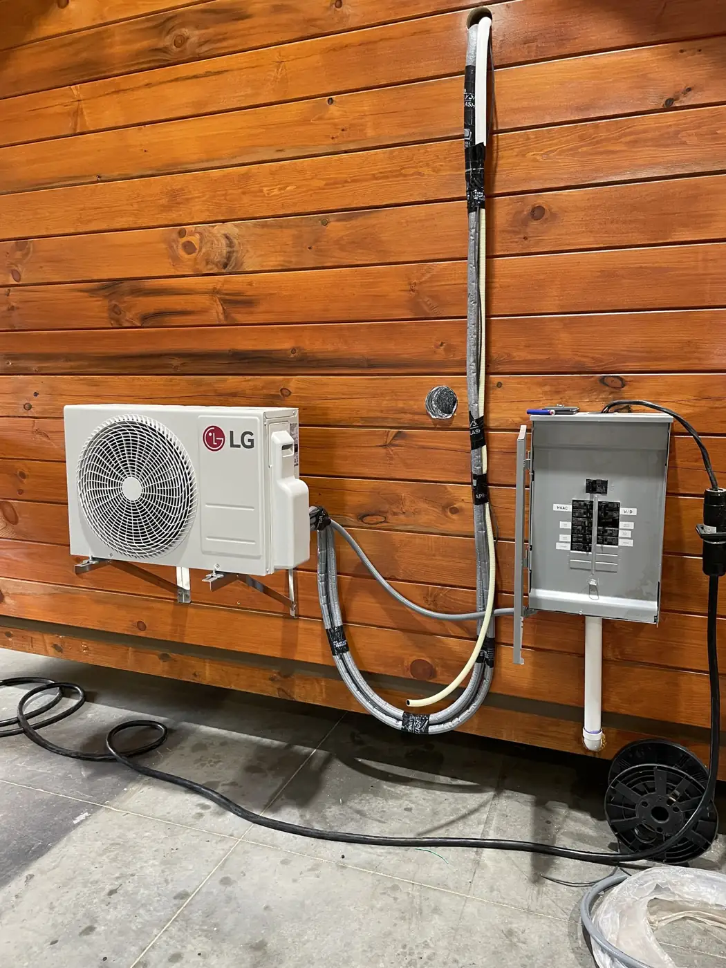 LG mini-split and electrical panel mounted on The Cub’s log wall