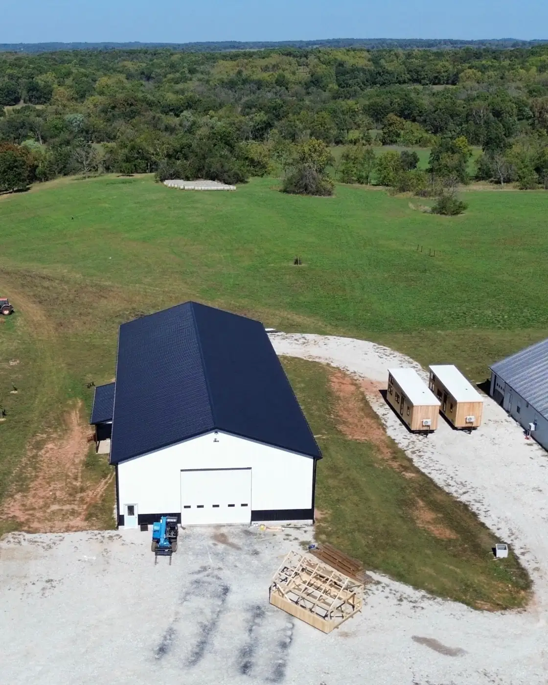 Aerial view of the Premium Structures shop in Fair Play, Missouri, with finished buildings on the gravel lot