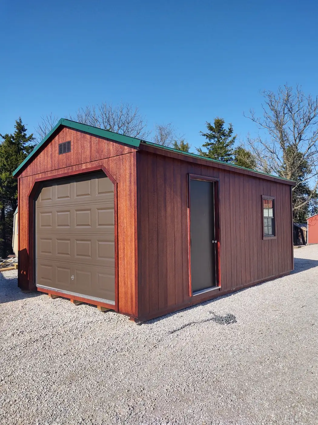 Barn red garage with a roll-up door, side door and white trim