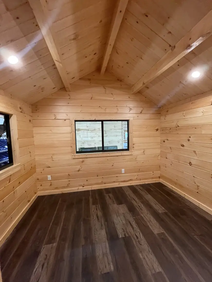 Bedroom with pine walls and a window centered on the gable wall