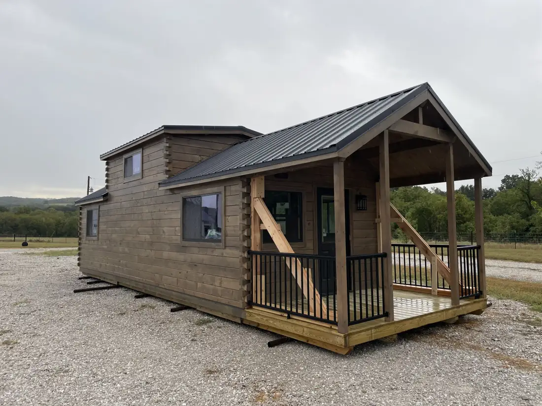 The Kodiak with its covered front porch and railings on a gravel lot