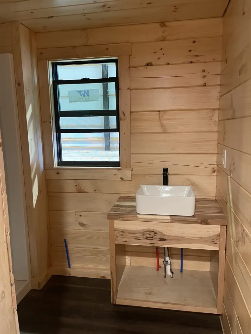 Vessel sink on a hickory vanity under a window