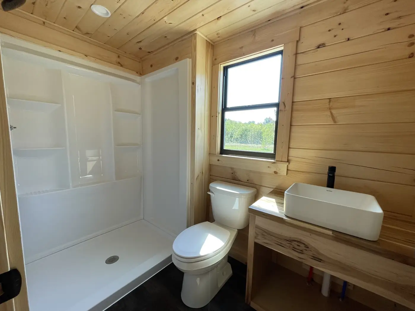 Kodiak bathroom with a walk-in shower, vessel sink and pine walls
