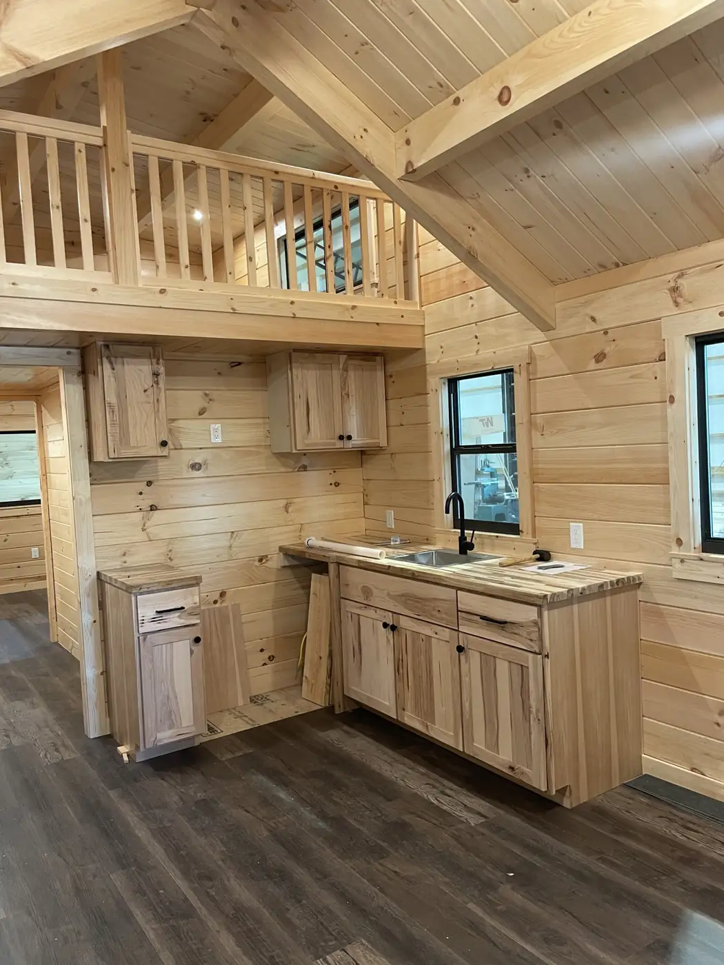Kodiak kitchen with hickory cabinets, butcher-block counters and a loft railing above