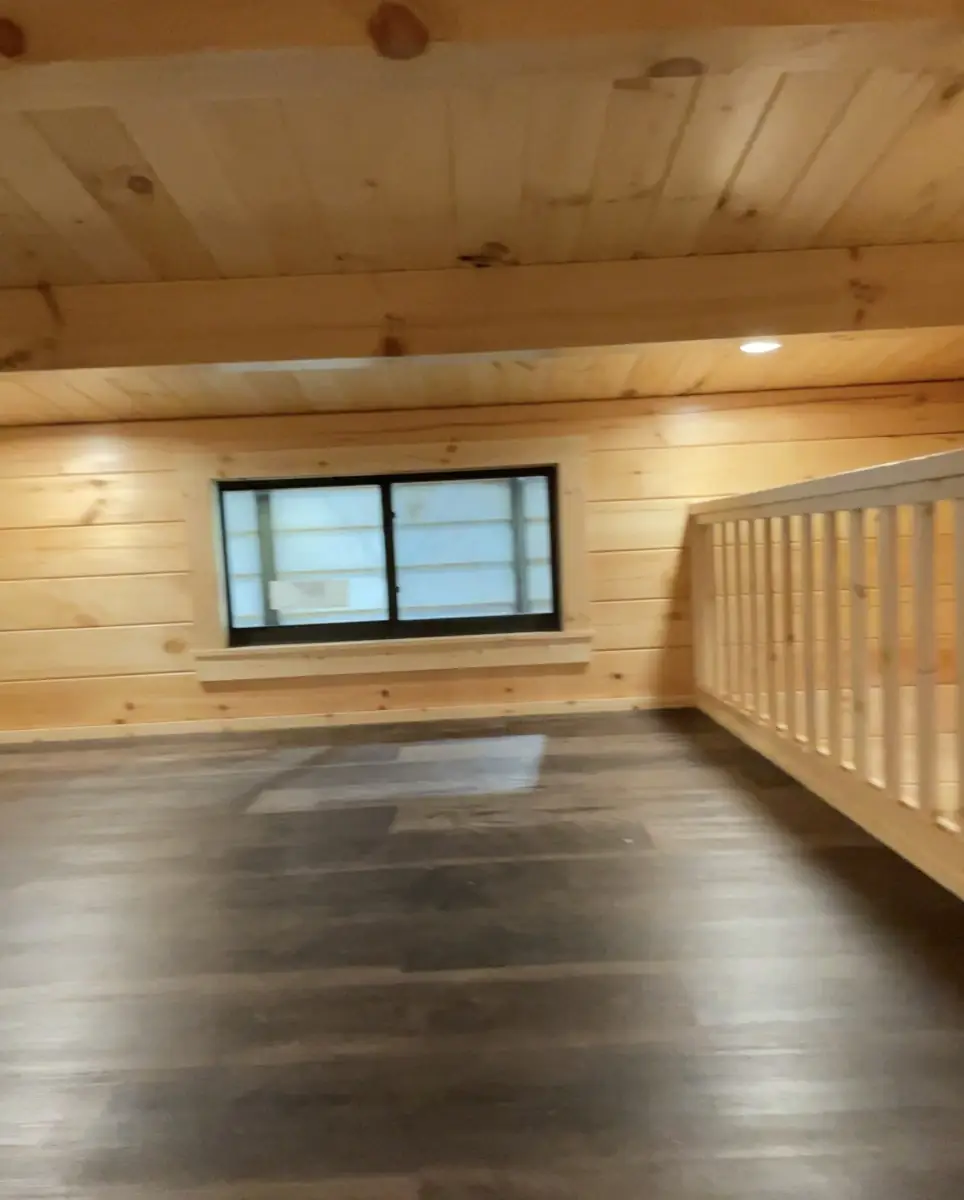 Inside the loft with a window and wood railing