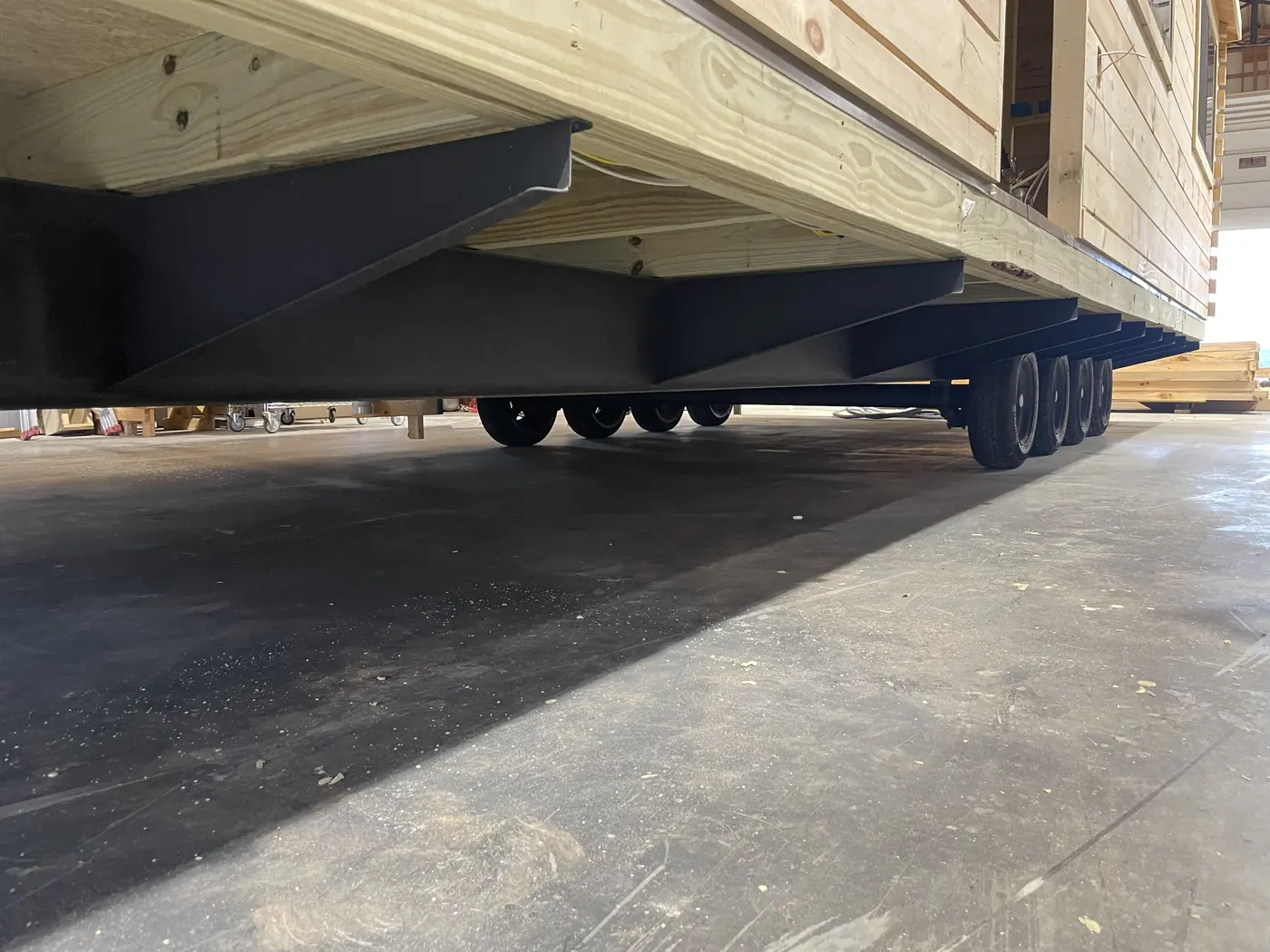 Steel chassis beams and axles under a cabin in the shop