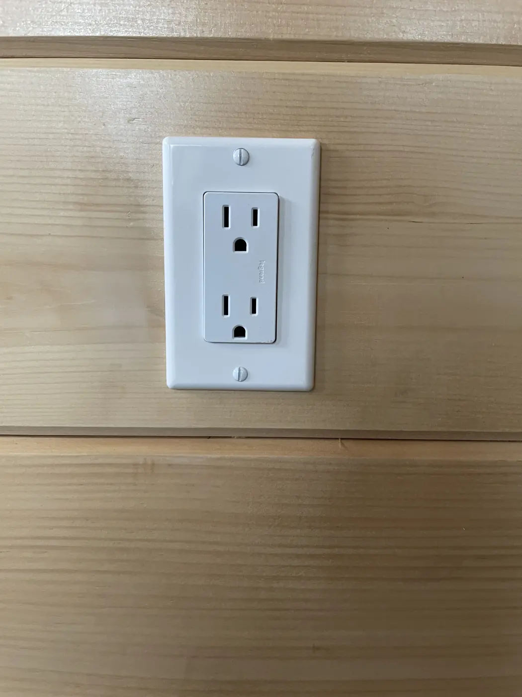 White wall outlet on the pine log wall
