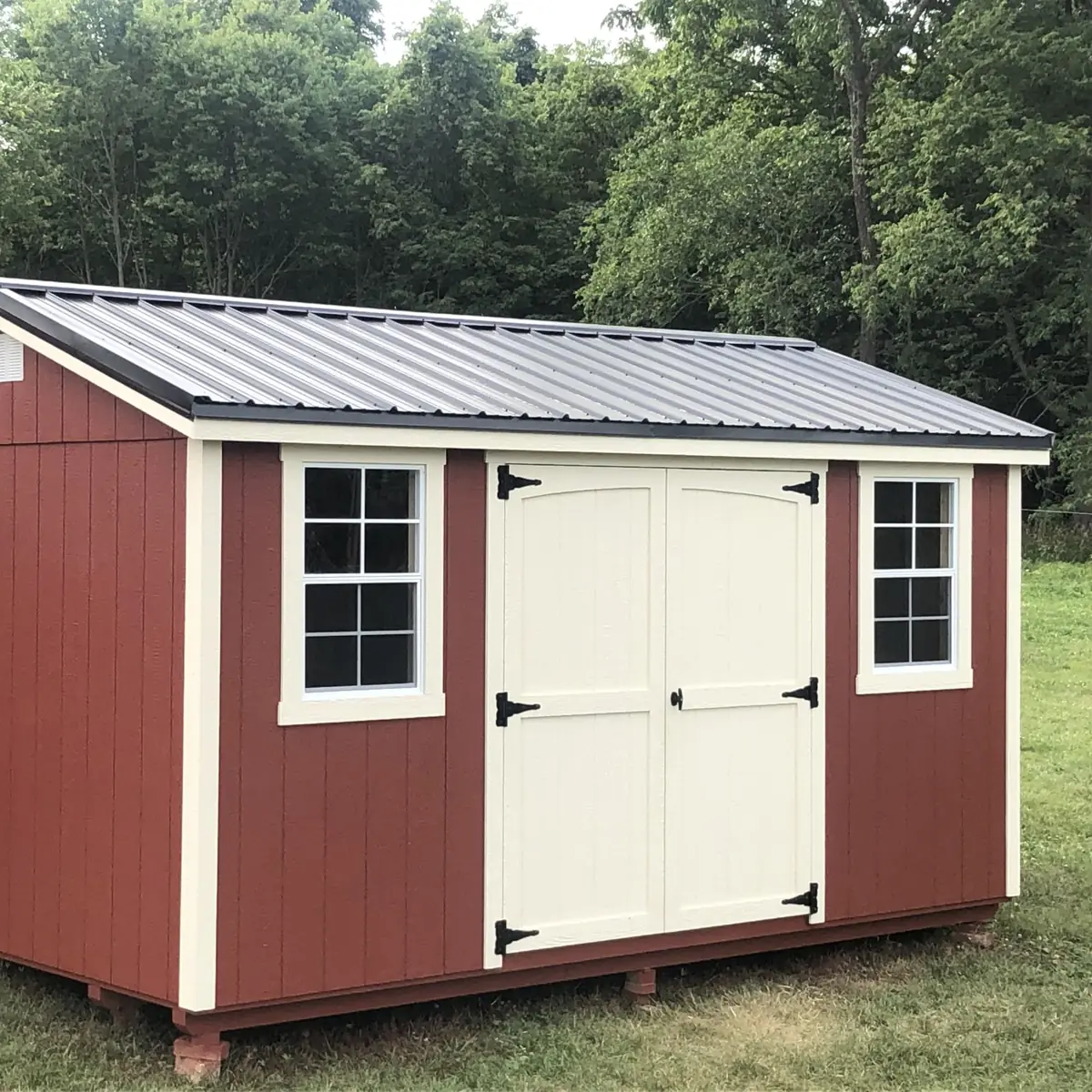 Barn red garden shed with cream double doors, two windows and a metal roof