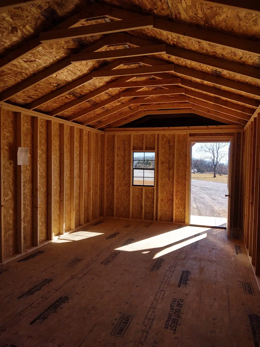 Inside a utility cabin: wood walls, open floor and a window at the far end